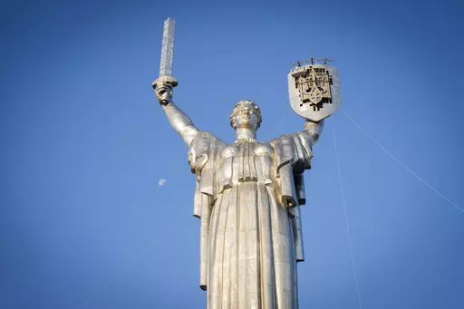 Workers install the Ukrainian coat of arms on the shield in the hand of the country's tallest stature, the Motherland Monument, after the Soviet coat of arms was removed, in Kyiv, Ukraine, Sunday, Aug. 6, 2023. Ukraine is accelerating efforts to erase the vestiges of centuries of Soviet and Russian influence from the public space amid the Russian invasion of Ukraine by pulling down monuments and renaming hundreds of streets to honor home-grown artists, poets, military chiefs, and independence le