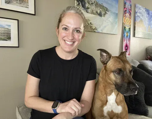 Lindsey Kee poses with her dog Teddy Ruffsavel at her home in Portland, Oregon, on Aug. 3, 2024. Kee created an exercise routine around walking her dog, (Lindsey Kee via AP)