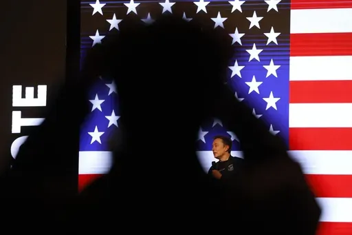 People listen to Elon Musk during a town hall Sunday, March 30, 2025, in Green Bay, Wis. (AP Photo/Jeffrey Phelps)