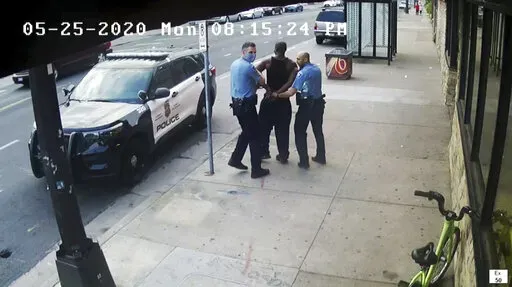 This image from video shows Minneapolis police Officers Thomas Lane, left and J. Alexander Kueng, right, escorting George Floyd, center, to a police vehicle outside Cup Foods in Minneapolis, on May 25, 2020. Three former Minneapolis officers headed to trial this week on federal civil rights charges in the death of George Floyd aren't as familiar to most people as Derek Chauvin, a fellow officer who was convicted of murder last spring. (Court TV via AP, Pool, File)
