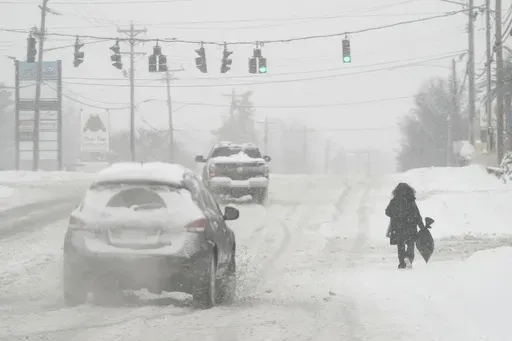 Heavy snow falls as a person walks along U.S. Route 42 in Florence, Ky., Monday, Jan. 6, 2025. (AP Photo/Carolyn Kaster, File)