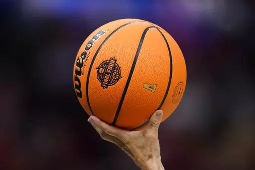 A referee holds up a ball during the second half of a college basketball game in the semifinal round of the Women's Final Four NCAA tournament between South Carolina and Louisville Friday, April 1, 2022, in Minneapolis. (AP Photo/Charlie Neibergall)