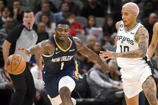 New Orleans Pelicans' Zion Williamson (1) and San Antonio Spurs' Jeremy Sochan chase the ball during the first half of an NBA basketball game, Wednesday, Nov. 23, 2022, in San Antonio. (AP Photo/Darren Abate)