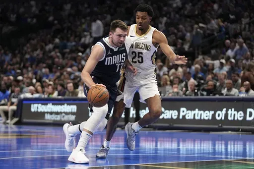 Dallas Mavericks guard Luka Doncic (77) drives to the basket as New Orleans Pelicans' Trey Murphy III (25) defends in the first half of an Emirates NBA Cup basketball game in Dallas, Tuesday, Nov. 19, 2024. (AP Photo/Tony Gutierrez)