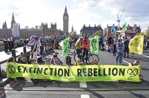 Demonstrators take part in an Extinction Rebellion protest on Westminster Bridge in London, Friday, April 15, 2022. Climate-change protesters have snarled traffic by blocking four London bridges. Cars and red double-decker buses backed up along roads as hundreds of Extinction Rebellion activists occupied London’s Waterloo, Blackfriars, Lambeth and Westminster bridges, calling for an end to new fossil fuel investments. (Stefan Rousseau/PA via AP)