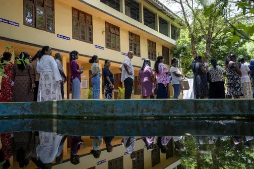 People wait in a queue to cast their votes at a polling center during the presidential election on the outskirts of Colombo, Sri Lanka Saturday, Sept. 21, 2024.(AP Photo/Rajesh Kumar Singh)