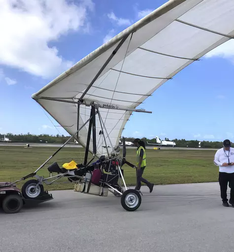 In this photo, provided by the Monroe County Sheriff's Office via the Florida Keys News Bureau, Key West International Airport personnel examine an ultralight aircraft that landed illegally at the airport carrying two Cuban men Saturday, March 25, 2023, in Key West, Fla. An airport spokesperson reported that both men were uninjured and were taken into custody by the Sheriff's Office. There were no interruptions in service and operations continue as normal, airport officials added. (Monroe County