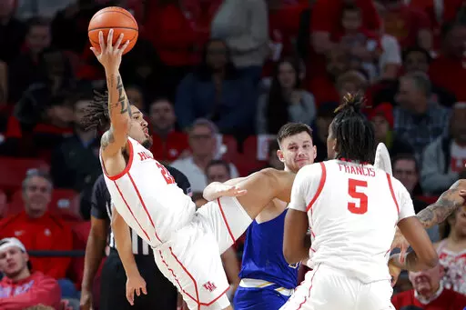 Houston guard Emanuel Sharp, left, falls backward on a rebound past McNeese State forward Roberts Berze, rear, and Houston forward Ja'Vier Francis (5) during the first half of an NCAA college basketball game Wednesday, Dec. 21, 2022, in Houston. (AP Photo/Michael Wyke)