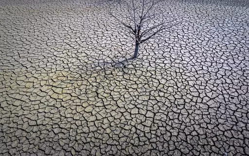 The cracked earth of the Sau reservoir is visible north of Barcelona, Spain, March 20, 2023. Earth last year shattered global annual heat records, the European climate agency said Tuesday, Jan. 9, 2024. (AP Photo/Emilio Morenatti, File)