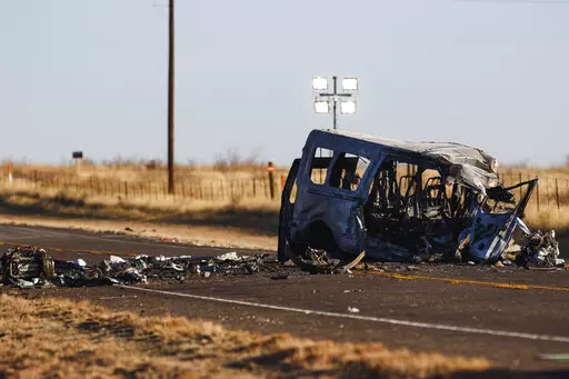 CORRECTS DAMAGE TO VAN FROM BUS - The damage van sits on the side of the road at the scene of a fatal car wreck early Wednesday, March 16, 2022 half of a mile north of State Highway 115 on Farm-to-Market Road 1788 in Andrews County, Texas. A pickup truck crossed the center line of a two-lane road in Andrews County, about 30 miles (50 kilometers) east of the New Mexico state line on Tuesday evening and crashed into a van carrying members of the University of the Southwest men's and women's golf t