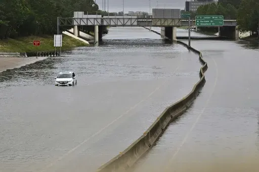 A vehicle is stranded on flooded Interstate 10 after Hurricane Beryl dumped rain, Monday, July 8, 2024, in Houston. As the city slowly struggles to recover after Hurricane Beryl left millions without power, experts say it's time to rethink how cities are preparing for and responding to weather disasters. (AP Photo/Maria Lysaker, File)