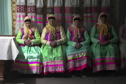 Women in traditional Doukhobor dresses pray at the former Orphanage house where Doukhobors has worshiped for years, on Easter in the remote mountain village of Gorelovka, Georgia, Saturday, May 4, 2024. (AP Photo/Kostya Manenkov)