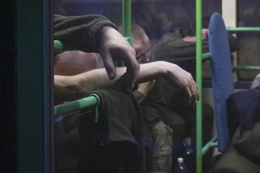 Ukrainian servicemen sit in a bus after they were evacuated from the besieged Mariupol's Azovstal steel plant, near a prison in Olyonivka, in territory under the government of the Donetsk People's Republic, eastern Ukraine, Tuesday, May 17, 2022. More than 260 fighters, some severely wounded, were pulled from a steel plant on Monday that is the last redoubt of Ukrainian fighters in the city and transported to two towns controlled by separatists, officials on both sides said. (AP Photo)