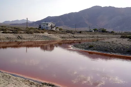 FILE— Clouds and nearby mountains are reflected in a polluted canal, once used as a boating dock, along the Salton Sea in Desert Shores, Calif., Wednesday, July 14, 2021. President Joe Biden on Tuesday, Feb. 22, 2022, pointed to plans to extract lithium from geothermal wastewater around the sea as an example of the Unites States' efforts to compete with China and other nations when it comes to domestic lithium production. The metal is a key element in rechargeable batteries, such as those used