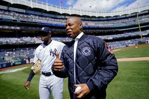New York City Mayor Eric Adams stands on the field with New York Yankees starting pitcher Luis Severino, left, before the Yankees opening day baseball game against the Boston Red Sox, Friday, April 8, 2022, in New York. (AP Photo/John Minchillo)