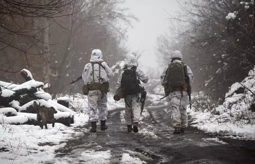 Ukrainian soldiers walks at the line of separation from pro-Russian rebels near Katerinivka, Donetsk region, Ukraine, Tuesday, Dec 7, 2021. Germany's refusal to join other NATO members in supplying Ukraine with weapons has frustrated allies and prompted some to question Berlin's resolve in standing up to Russia. (AP Photo/Andriy Dubchak)