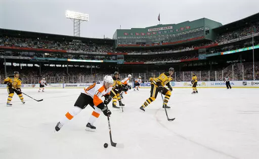 FILE — Philadelphia Flyers center Danny Briere (48) skates with the puck as Boston Bruins defenseman Zdeno Chara, right, defends in the second period of the New Year's Day Winter Classic NHL hockey game on an outdoor rink at Fenway Park in Boston, Jan. 1, 2010. Fenway Park has kept busy in the offseason with hockey, football and other events that have turned one of baseball's crown jewels into a year-round venue. (AP Photo/Elise Amendola, File)