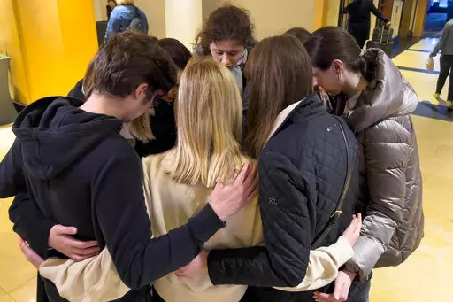 Mariia Pachenko, top center, huddles with Ukrainian peers in prayer on April 8, 2022, as the group disbands after spending nearly a week together taking part in the National Model United Nations Conference in New York. (AP Photo/Bobby Caina Calvan)