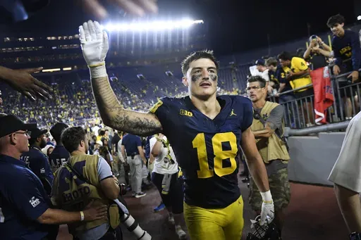Michigan's Colston Loveland celebrates with fans following an NCAA college football game against Fresno State, Saturday, Aug. 31, 2024, in Ann Arbor, Mich. (AP Photo/Jose Juarez)
