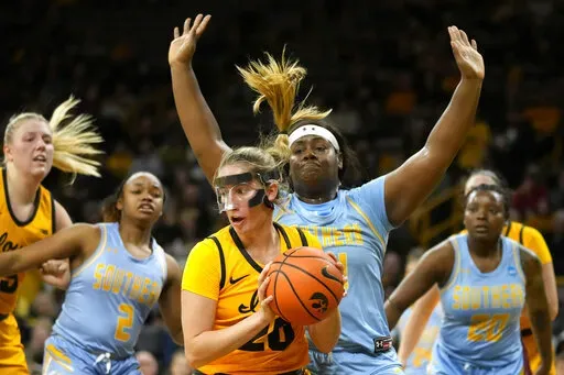Iowa guard Kate Martin (20) grabs a rebound in front of Southern forward Raven White (44) during the first half of an NCAA college basketball game, Monday, Nov. 7, 2022, in Iowa City, Iowa. (AP Photo/Charlie Neibergall)