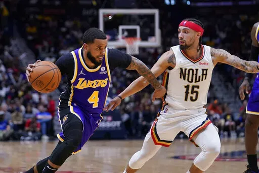 Los Angeles Lakers guard D.J. Augustin (4) drives to the basket against New Orleans Pelicans guard Jose Alvarado (15) in the first half of an NBA basketball game in New Orleans, Sunday, March 27, 2022. The Pelicans won 116-108. (AP Photo/Gerald Herbert)