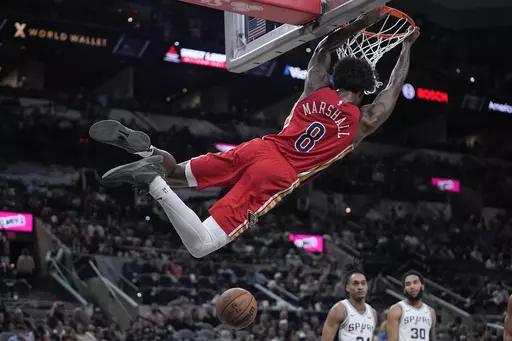 New Orleans Pelicans forward Naji Marshall (8) swings from the rim after scoring against the San Antonio Spurs during the second half of an NBA basketball game in San Antonio, Sunday, Dec. 17, 2023. (AP Photo/Eric Gay)