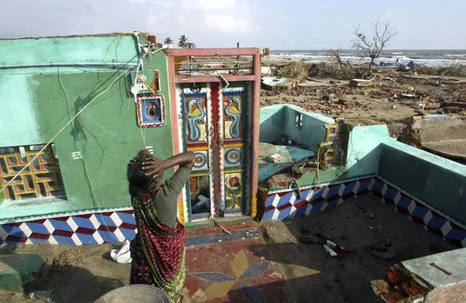 Paliyamma grieves on returning to her damaged house at a fishermen's colony hit by tsunami, in Nagappattinam, in the southern Indian state of Tamil Nadu, Friday, Dec. 31, 2004. Paliyamma lost seven members of her family. (AP Photo/Gurinder Osan, File)