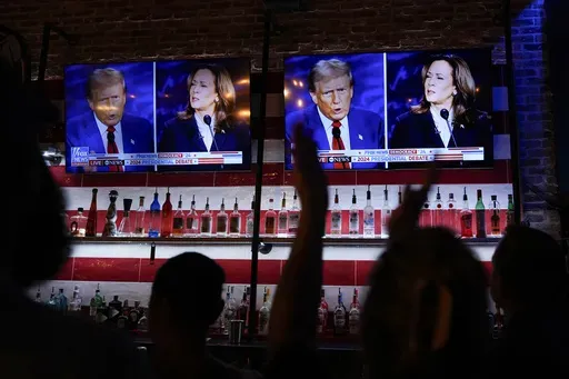 Viewers cheer as they watch a debate between Democratic presidential nominee Vice President Kamala Harris and Republican presidential nominee former President Donald Trump at the Angry Elephant Bar and Grill, Sept. 10, 2024, in San Antonio. (AP Photo/Eric Gay, File)