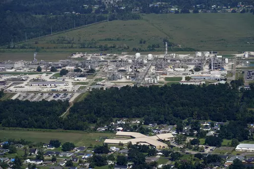 The Fifth Ward Elementary School and residential neighborhoods sit near the Denka Performance Elastomer Plant, back, in Reserve, La., Sept. 23, 2022. In what could prove a significant move for communities facing air pollution, the Environmental Protection Agency proposed on Thursday, April 6, 2023, that chemical plants nationwide measure certain hazardous compounds that cross beyond their property lines and reduce them when they are too high. (AP Photo/Gerald Herbert, File)