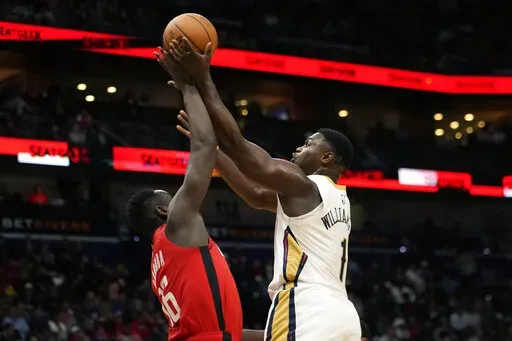 New Orleans Pelicans forward Zion Williamson (1) goes to the basket against Houston Rockets forward Usman Garuba in the first half of an NBA basketball game in New Orleans, Saturday, Nov. 12, 2022. (AP Photo/Gerald Herbert)