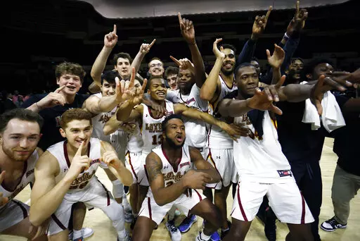 Loyola (La.) celebrates a 71-56 win against Talladega in the NAIA national championship college basketball game Tuesday, March 22, 2022, in Kansas City, Mo. (AP Photo/Colin E. Braley)