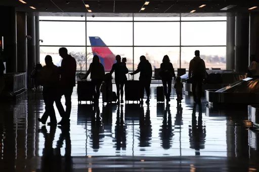 People pass through Salt Lake City International Airport Wednesday, Jan. 11, 2023, in Salt Lake City. To catch up with your credit-savvy friends, you may be considering a credit card that earns cash-back or travel rewards. If you have one already, perhaps you want to add a second card to the mix to earn even more. (AP Photo/Rick Bowmer, File)