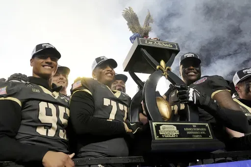 Army players hoist the winner's trophy following their win over Louisiana Tech during a NCAA college football game, Saturday, Dec. 28, 2024, in Shreveport, La. (AP Photo/Rogelio V. Solis)