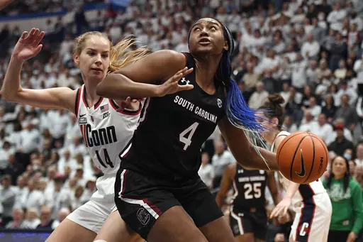 South Carolina's Aliyah Boston (4) drives to the basket as UConn's Dorka Juhasz (14) defends in the second half of an NCAA college basketball game, Sunday, Feb. 5, 2023, in Hartford, Conn. Boston was honored for the third straight year as an All-American by The Associated Press on Wednesday, March 15, 2023.(AP Photo/Jessica Hill, File)