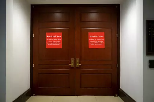 Bright red signs alert non-authorized personnel at the entrance to the House SCIF, the Sensitive Compartmented Information Facility, located three levels beneath the Capitol where witnesses and lawmakers hold closed interviews in the impeachment inquiry on President Donald Trump's efforts to press Ukraine to investigate his political rivals, in Washington, Nov. 6, 2019. When members of Congress want to peruse classified materials, they descend deep into the basement of the Capitol to a sensitive