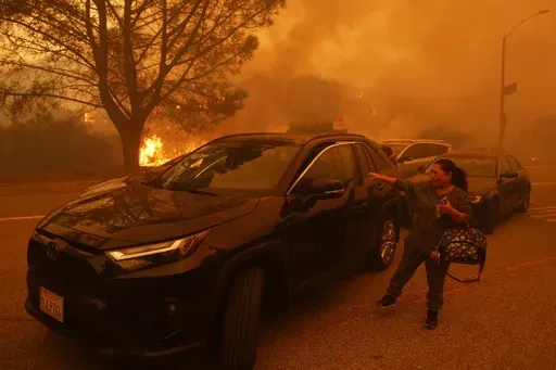 A woman cries as the Palisades Fire advances in the Pacific Palisades neighborhood of Los Angeles, Tuesday, Jan. 7, 2025. (AP Photo/Etienne Laurent)