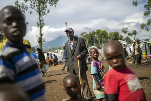 People displaced by the fighting between M23 rebels and FARDC government forces gather North of Goma, Democratic Republic of Congo, on Nov. 25, 2022. Hundreds of thousands of people have been uprooted from their homes by fighting that began over a year ago in eastern Congo between M23 rebels, militias and government forces. (AP Photo/Jerome Delay, File)