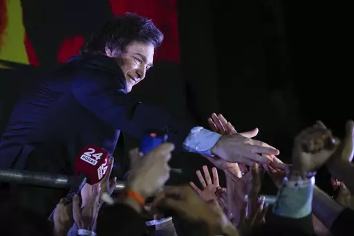 Presidential candidate of the Liberty Advances coalition Javier Milei greets supporters outside his campaign headquarters after winning the presidential runoff election in Buenos Aires, Argentina, Sunday, Nov. 19, 2023. (AP Photo/Natacha Pisarenko)