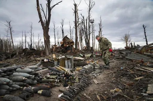 An interior ministry sapper collects unexploded shells, grenades and other devices in Hostomel, close to Kyiv, Ukraine, Monday, April 18, 2022. (AP Photo/Efrem Lukatsky)