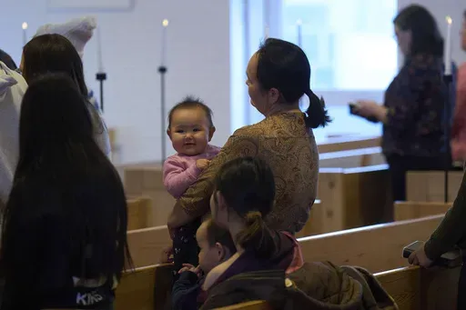 A baby is held by her mother as they attend a religious service at Hans Egede Church in Nuuk, Greenland, Sunday, Feb. 16, 2025. (AP Photo/Emilio Morenatti)