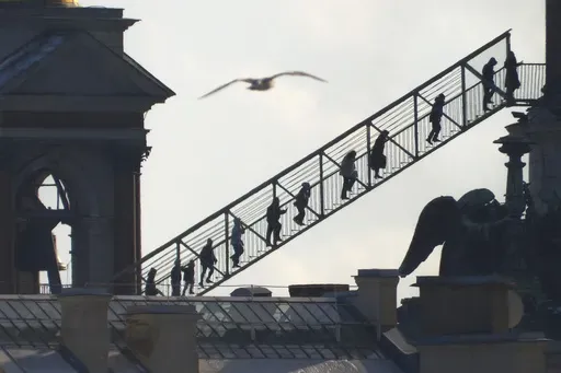 People climb to the observation deck on the colonnade of St. Isaac's Cathedral in central St. Petersburg, Russia, Saturday, March 15, 2025. (AP Photo/Dmitri Lovetsky)