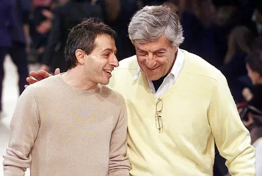 American-Greek designer Peter Speliopoulos, left, and Nino Cerruti talk on the catwalk after their fall-winter ready-to-wear fashion show presentation in Paris, Thursday March 15, 2001. Cerruti, the Italian fashion designer credited with revolutionizing menswear in the 1960s and who gave Giorgio Armani his first fashion break, has died, Italian media reported Saturday, Jan. 15, 2022. He was 91. (AP Photo/Michel Euler, File)
