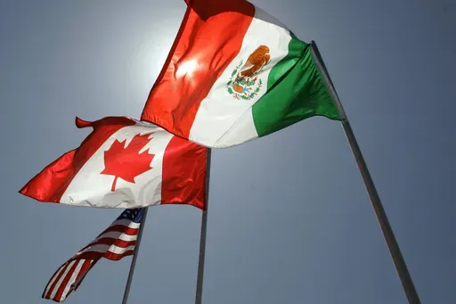 National flags representing the United States, Canada, and Mexico fly in the breeze in New Orleans where leaders of the North American Free Trade Agreement met on April 21, 2008. (AP Photo/Judi Bottoni, File)
