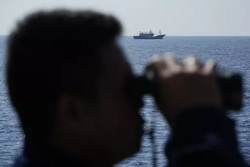 A suspected Chinese militia ship passes as members onboard the Philippine Coast Guard BRP Malabrigo drives them away from Philippine-occupied areas in the South China Sea on Friday, April 21, 2023. (AP Photo/Aaron Favila)