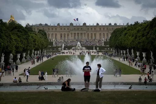 Visitors enjoy the Chateau de Versailles gardens, outside Paris, France, on July 15, 2023. France is rolling out the red carpet for King Charles III's state visit starting on Wednesday Sept. 20, 2023 at one of its most magnificent and emblematic monuments: the Palace of Versailles, which celebrates its 400th anniversary. (AP Photo/Christophe Ena, File)