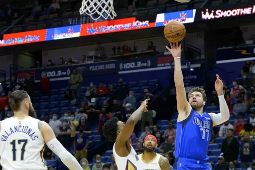 Dallas Mavericks guard Luka Doncic (77) shoots against New Orleans Pelicans forward Herbert Jones during the first half of an NBA basketball game in New Orleans, Thursday, Feb. 17, 2022. (AP Photo/Matthew Hinton)