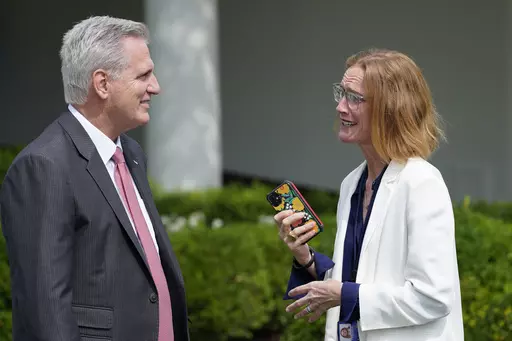 House Speaker Kevin McCarthy of Calif., left, talks with White House director of legislative affairs Louisa Terrell, right, before the start of an event in the Rose Garden of the White House in Washington, July 26, 2021. President Joe Biden and McCarthy are turning to a select group of negotiators to help broker a deal to increase the nation’s borrowing authority. (AP Photo/Susan Walsh, File)