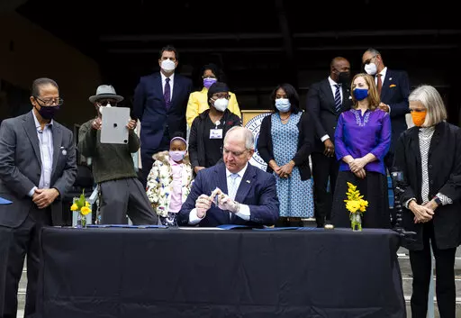 Gov. John Bel Edwards pardons Homer Plessy during the Posthumous Pardoning Ceremony for Homer Plessy at the New Orleans Center for Creative Arts in New Orleans, Wednesday, Jan. 5, 2022. Louisiana’s governor on Wednesday posthumously pardoned Plessy, the Black man whose arrest for refusing to leave a whites-only railroad car in 1892 led to the Supreme Court ruling that cemented “separate but equal” into U.S. law for half a century. (Sophia Germer/The Advocate via AP)