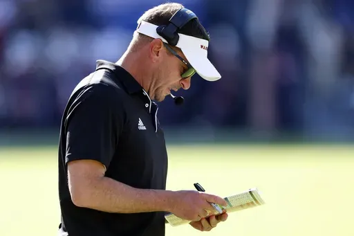 Louisiana Monroe head coach Bryant Vincent looks at his play card during the first half of an NCAA college football game against Auburn, Saturday, Nov. 16, 2024, in Auburn, Ala. (AP Photo/ Butch Dill)