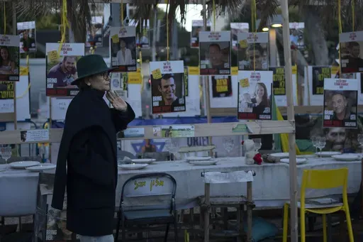 A woman looks at a display of empty chairs representing hostages held by the Hamas militant group in the Gaza Strip in Tel Aviv, Israel, Friday, Jan. 24, 2025. (AP Photo/Maya Alleruzzo)